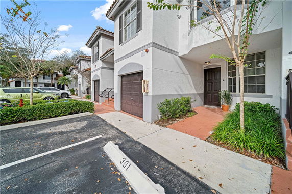 Front view of a townhouse with a garage and entryway.