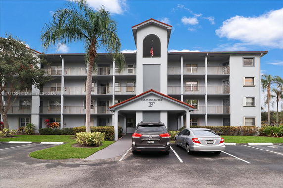 Front view of a multi-story apartment building with a parking area.