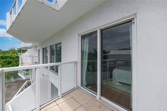 View from a building balcony showing sliding doors and the surrounding area.