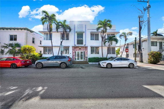 Front view of a two-story building with palm trees.