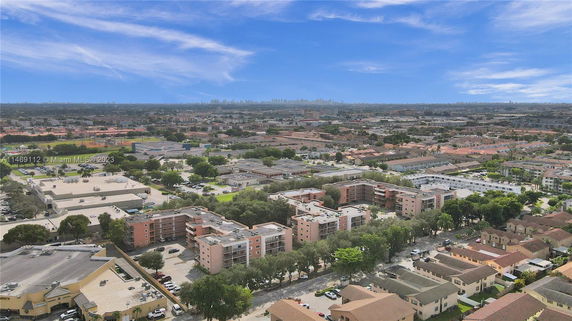 Aerial panoramic view of a residential and commercial area with buildings and roads.