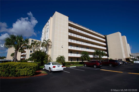 Front view of a multi-story apartment building with balconies.