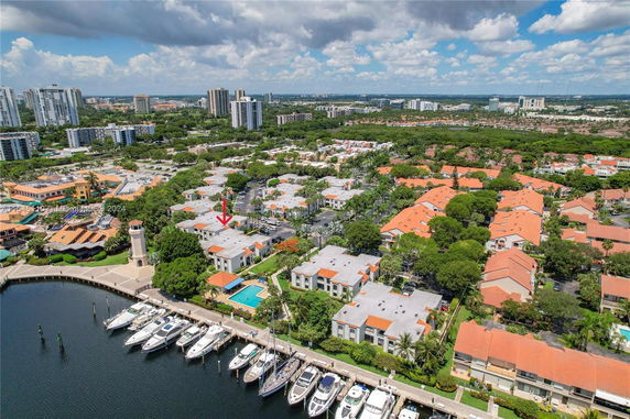 Aerial view of residential area with apartment buildings near a marina and waterfront.