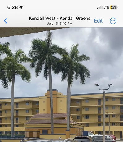 Front view of a multi-story building with palm trees in the foreground.