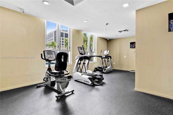Exercise room with fitness equipment and windows.