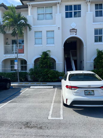 Outdoor parking area in front of a residential building.