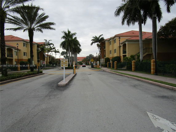 View from the road of apartment buildings with palm trees.