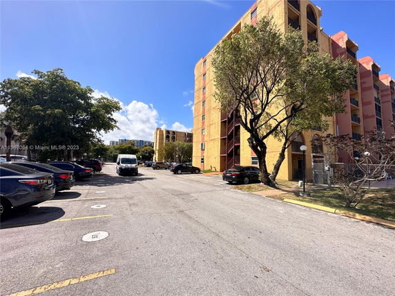 Outdoor parking area beside a multi-story building.