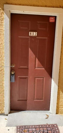 Brown entrance door with a house number 812.
