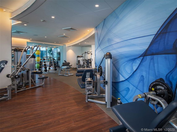 Indoor gym area with various exercise equipment and a decorative blue wall.