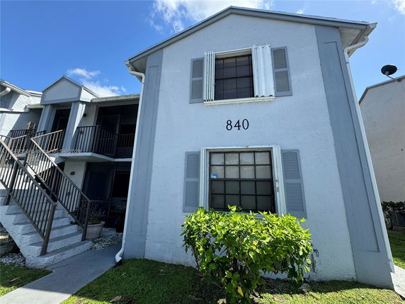Front view of a two-story residential building with an exterior staircase.