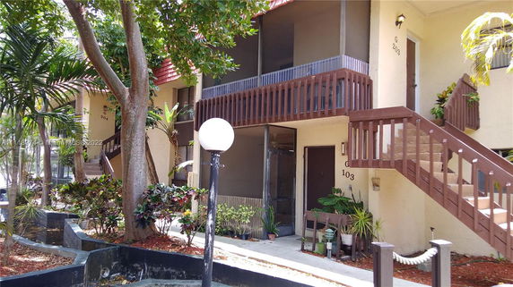 Front view of a multi-story residential building with exterior staircases and balconies.