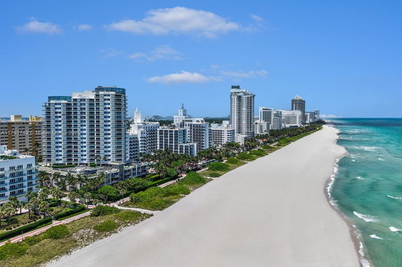 Panoramic view of a beachfront cityscape with high-rise buildings along a sandy beach.