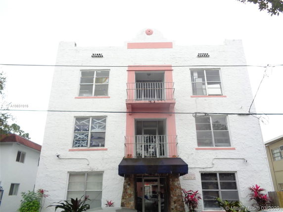 Front view of a multi-story building with balconies and large windows.