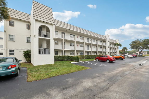 Front view of a three-story building with a parking area.