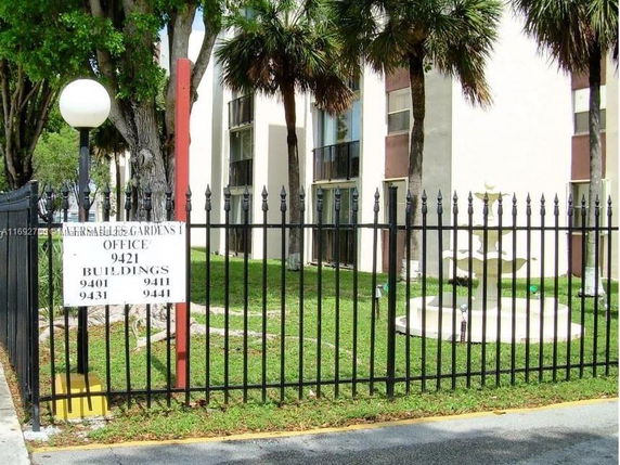 Front view of a multi-story building with a gated entrance.