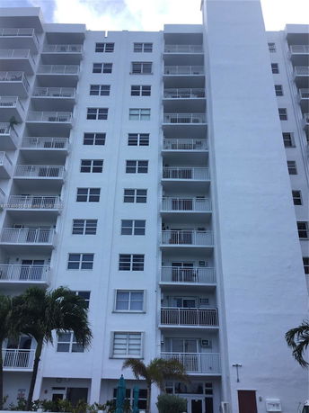 Front view of a multi-story apartment building with balconies.