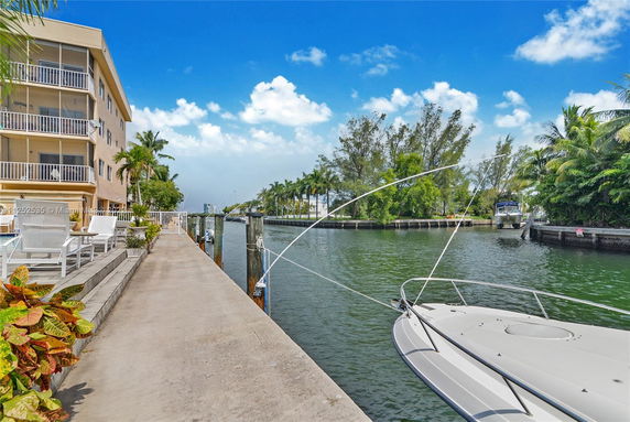 View of a canal with a nearby building and boats docked along the water.