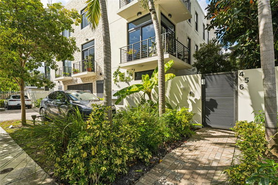 Front view of a multi-story building with balconies and modern facade.