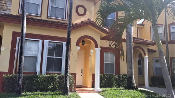 Front view of a two-story house with pillars and arched entryway.