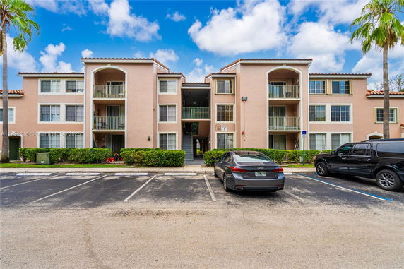 Front view of a three-story apartment building with balconies.