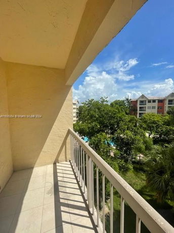 Panoramic view from a balcony overlooking nearby buildings and trees.
