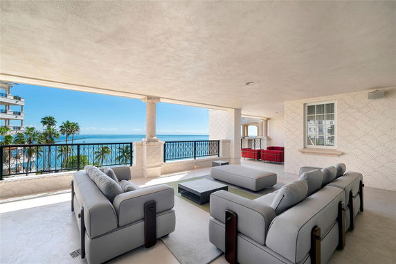 Open terrace with seating and ocean view from a high-rise building.