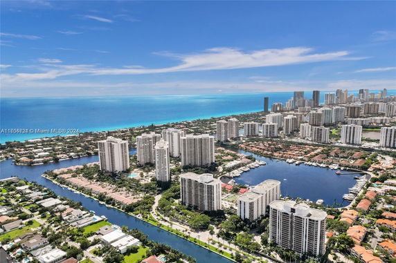 Aerial view of a coastal city with numerous high-rise buildings near a waterfront.