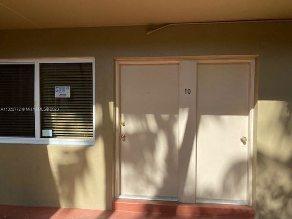 Front view of a building with a window and a door labeled '10'.