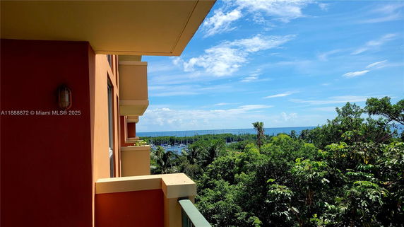View from the building showing a scenic panorama of trees and the ocean in the distance.