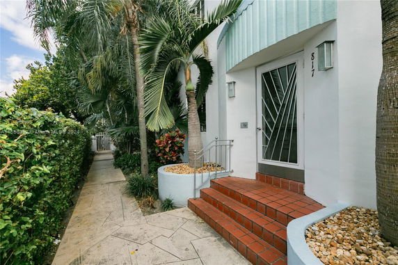 Front view of a house entrance with red steps and a modern door.