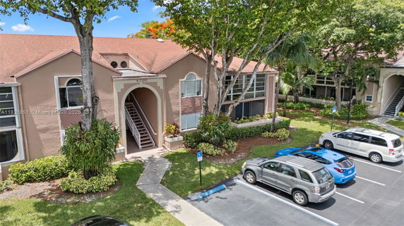 Front view of a two-story residential building with a large central archway entrance.