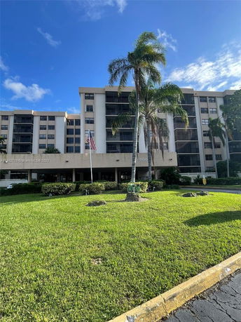 Front view of a multi-story residential building with balconies and an entrance area