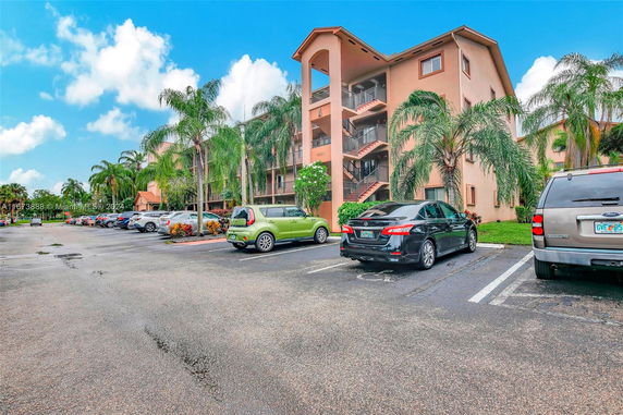 Outdoor parking area in front of a multi-story residential building.