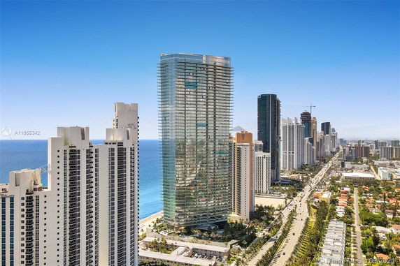 View of tall modern skyscrapers in an urban area near the ocean.