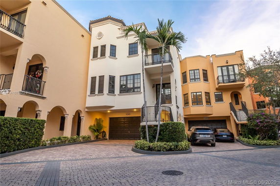 Front view of a multi-story residential building with balconies and garage.