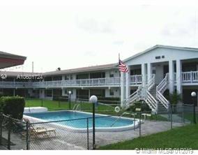 Outdoor view of a multi-story building with a swimming pool in the foreground.