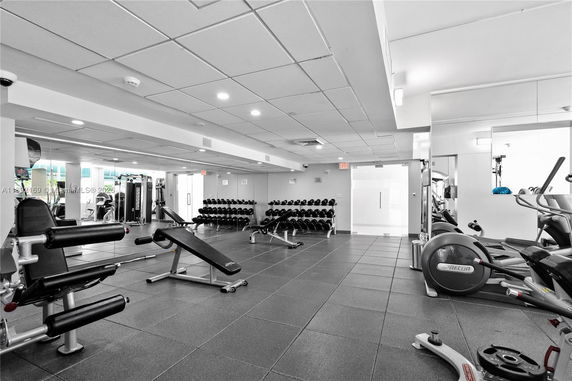 Interior view of a gym facility with various exercise equipment and weights.
