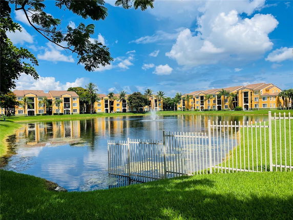 View of apartment buildings with a pond and fountain in front