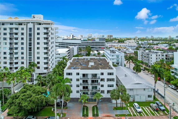 Aerial view of a mid-rise residential building with surrounding area in an urban environment