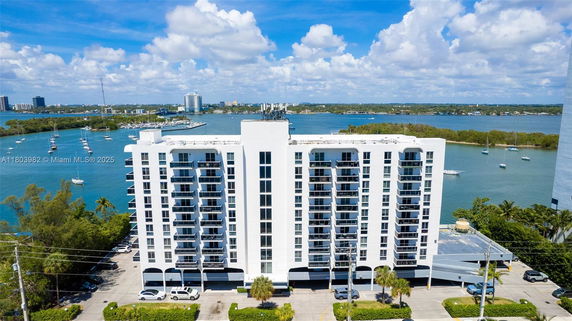 Front view of a multi-story building with balconies overlooking the water.