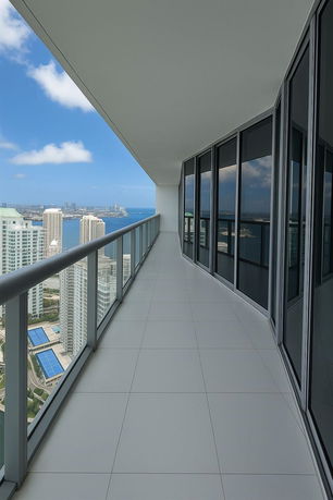 Balcony view from a high-rise building overlooking the city and water.