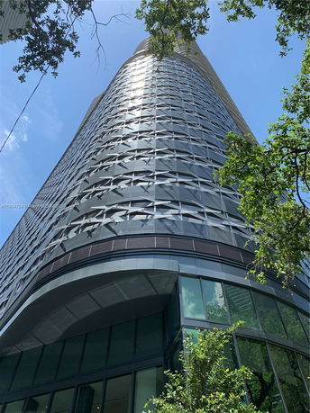 View from below of a modern skyscraper with a unique patterned facade.