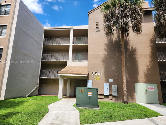 Front view of a multi-story apartment building with balconies.