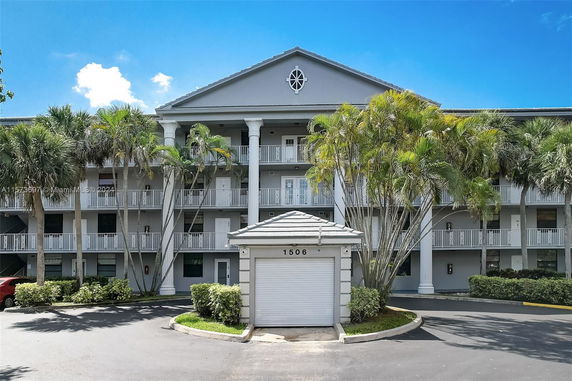 Front view of a multi-story residential building with balconies and columns.
