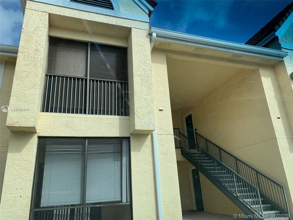 Front view of a two-story apartment building with exterior stairs.