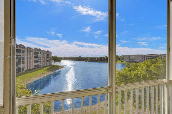 View of a lake and surrounding buildings from a balcony.