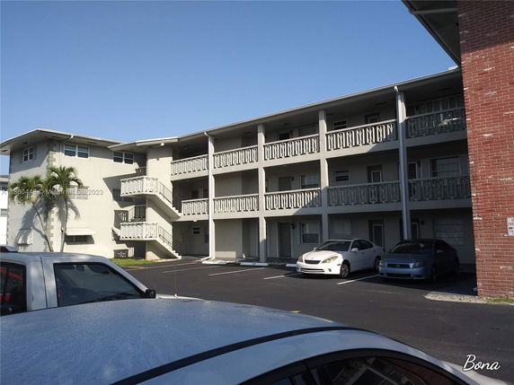 Front view of a multi-story apartment building with exterior staircases.