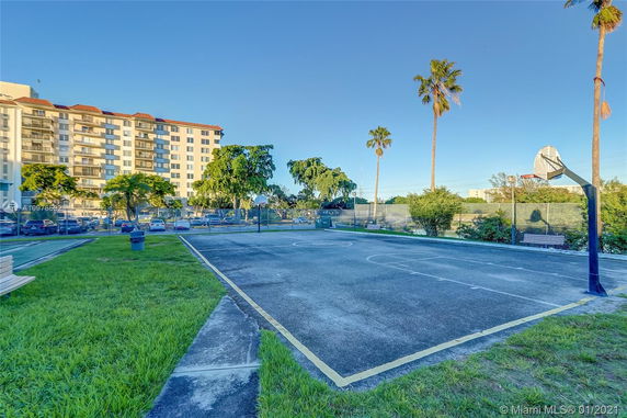 Outdoor basketball court near a multi-story residential building.