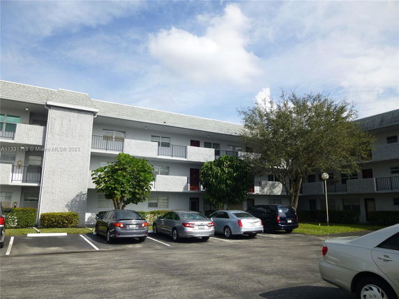 Parking area in front of a multi-story building.